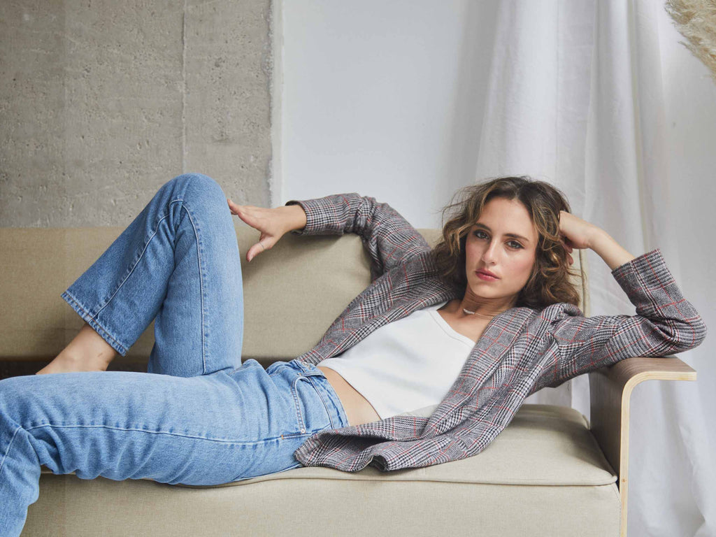 Faded line Nola Oversized checked blazer with real pockets shown in a model who is laying down on a sofa made in Barcelona ethically