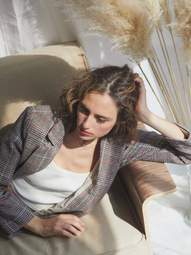 faded line nola oversized blazer made of dead-stock fabric in Barcelona the model is laying down on the studio